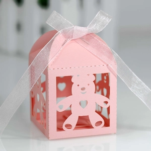 Pink laser-cut bear and heart paper candy box with a white ribbon bow for parties
