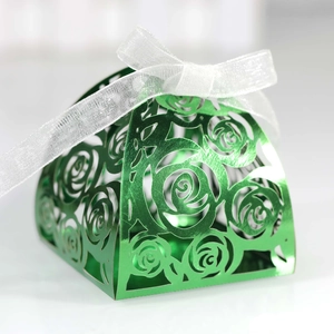 Detail of green laser-cut gift box with intricate rose patterns and white chiffon ribbon