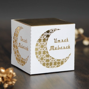 Detailed view of the white and gold Umrah Mubarak gift box with hollow moon pattern