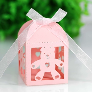 Detailed laser-cut hollow bear and heart pattern on pink house-shaped gift box with white ribbon