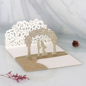 Detail of 3D laser-cut wedding card showing a romantic couple under a floral archway