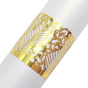 Macro detail of laser-cut gold paper napkin ring with elegant floral vine pattern