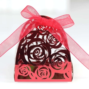 Close-up of red laser-cut rose hollow favor box with translucent organza ribbon bow