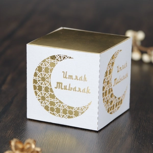 Detail of Umrah Mubarak white gift box featuring golden laser cut moon pattern on wood