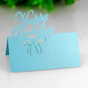 Macro view of light blue pearlescent laser-cut Happy Birthday place card with ribbon detail