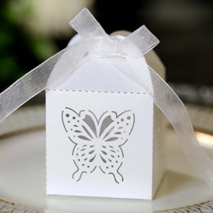 Close-up of laser-cut butterfly wedding candy box with a white organza ribbon bow