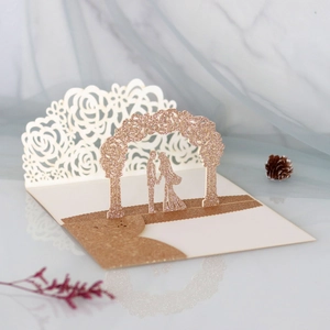 Detail of laser-cut 3D wedding card featuring rose gold glitter rose arch and couple