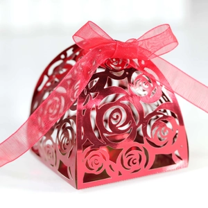 Detail of red hollow rose laser-cut gift box with glossy finish and ribbon bow