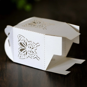 Detailed close-up of laser-cut butterfly pattern on a pearlescent white wedding gift box