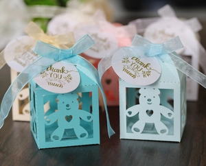 Detail van holle beer geschenkdozen met linten en bedanklabels in diverse pastelkleuren