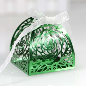 Macro shot of laser-cut green metallic rose pattern gift box with white silk ribbon