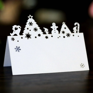 Laser-cut white pearl paper Christmas place cards with festive reindeer and snowflake designs