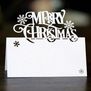 Detailed macro view of laser-cut Merry Christmas white seat card with snowflake patterns