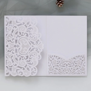 Detailed laser-cut floral pattern on a white elegant wedding invitation card