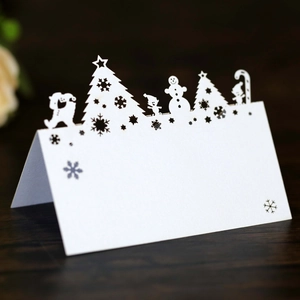 Laser-cut white Christmas table cards with snowflake texture and festive icons