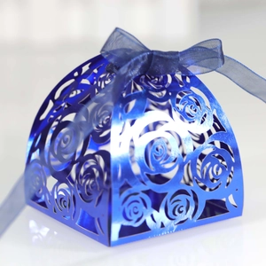 Close-up of laser-cut rose hollow patterns on a shiny blue metallic wedding candy box