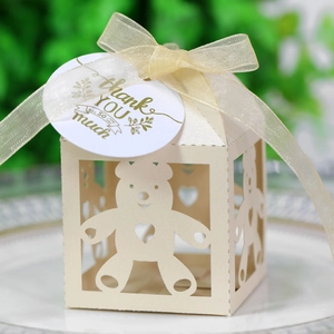 Detail van beige holle snoepdoos met beer en hart, goud lint goud en bedankje label