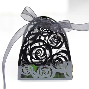Detail of laser-cut rose pattern on black candy box with elegant organza ribbon