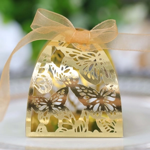 Detail of laser-cut butterfly hollow candy box with golden mirror finish and ribbon