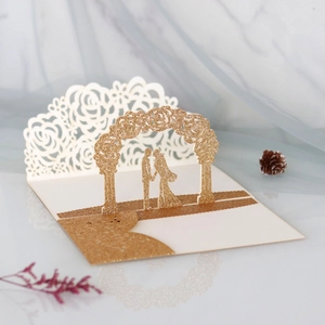 Macro detail of laser-cut glitter gold 3D wedding card featuring a romantic couple