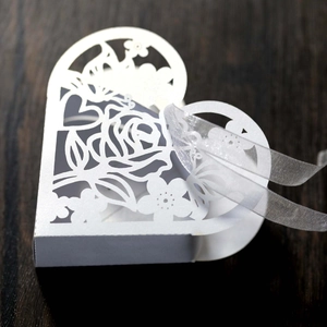 Détail macro des motifs de roses découpés au laser sur une boîte cadeau de mariage blanche