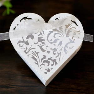 Vista macro della scatola regalo bianca a forma di cuore tagliata al laser con nastro
