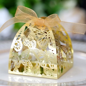 Detail view of laser-cut butterfly hollow candy box with gold metallic finish and ribbon