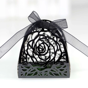 Detail of laser-cut black gift box featuring rose patterns and a black ribbon bow