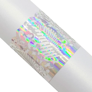 Close-up of laser-cut leaf napkin ring with holographic rainbow finish for weddings