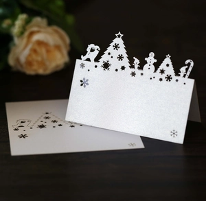 Laser cut Christmas place cards featuring snowflake and deer motifs on pearlescent paper