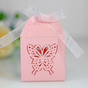 Close-up of pink laser-cut butterfly candy box with a white organza ribbon bow