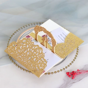 Intricate laser-cut 3D pop-up wedding invitation with gold glitter finish and floral design