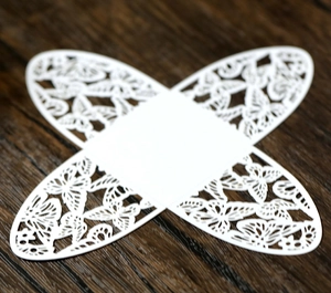 Flat lay of white laser-cut paper candy box with intricate butterfly and floral patterns