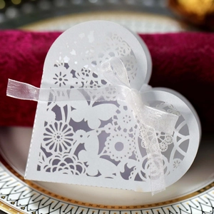 Detail of white laser-cut butterfly heart gift box with elegant floral patterns and ribbon