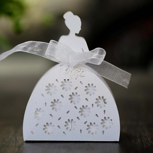 Detail of laser-cut wedding favor box with white bridal silhouette and organza ribbon