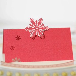 Détail d'un marque-place rouge découpé au laser avec motif de flocon de neige élégant