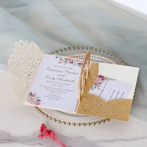 Detail of laser-cut rose invitation with gold glitter pocket and floral inner card