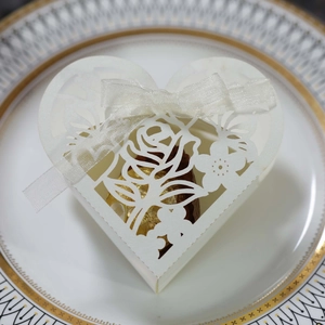 Détail de la boîte à bonbons cœur découpée au laser blanche avec motif rose et ruban