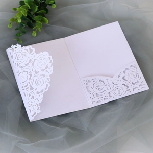 Macro detail of laser-cut rose floral pattern on premium white pearl paper invitation