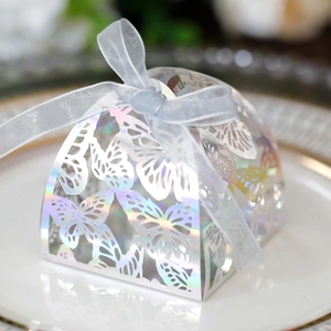 Close-up of laser-cut butterfly candy box with iridescent finish and white ribbon bow