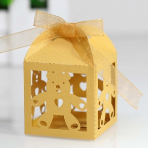 Detailed laser cut bear pattern on pearlescent yellow candy gift box with ribbon