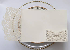 Detail of laser-cut lace pattern on ivory pearlescent paper wedding invitation cover