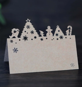 Macro detail of laser-cut snowflake and reindeer Kraft paper Christmas place cards