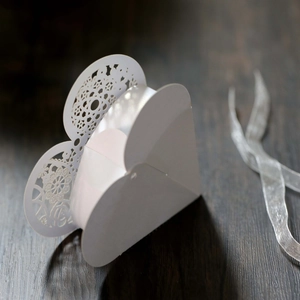 Detail of laser-cut butterfly and heart pattern on white wedding favor box