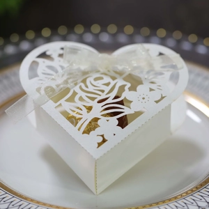 Détail de boîte à bonbons cœur découpée au laser avec motif rose et ruban sur assiette
