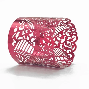 Detailed macro view of laser-cut filigree vine pattern on metallic pink napkin ring