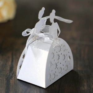 Detail of white laser-cut wedding favor box featuring bride silhouette and silk ribbon