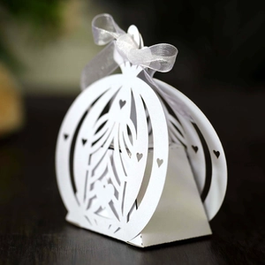 Macro detail of laser-cut white carriage wedding favor box with heart patterns
