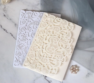 Detailed laser-cut lace floral hollow patterns on elegant cream and white wedding invites