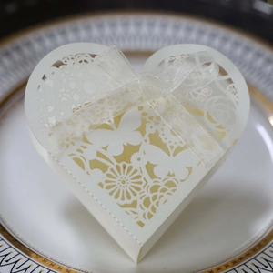 Detail of laser-cut heart candy box with ivory butterfly pattern and silk ribbon bow